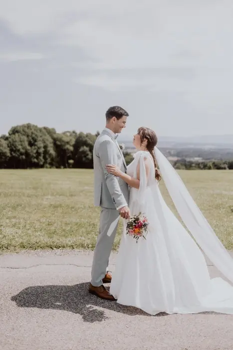 Hochzeitsfotograf Bayern Brautpaar in freier Natur unter sonnigem Himmel Dokumentarische Editorial Hochzeitsfotografie