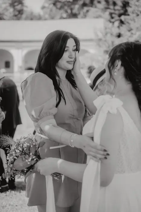 Hochzeitsfotograf Bayern Zwei Frauen umarmen sich auf einer Hochzeit im Freien Dokumentarische Editorial Hochzeitsfotografie