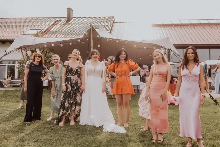 Hochzeitsfotograf Bayern Braut und Freunde posieren für ein Foto bei einer Sommerhochzeit Dokumentarische Editorial Hochzeitsfotografie