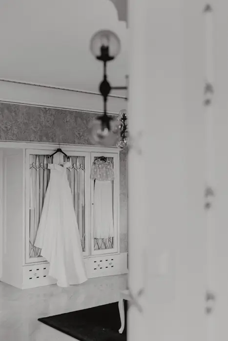 Hochzeitsfotograf Bayern Schwarzweiß-Fotografie eines Brautkleides im Ankleideraum Dokumentarische Editorial Hochzeitsfotografie