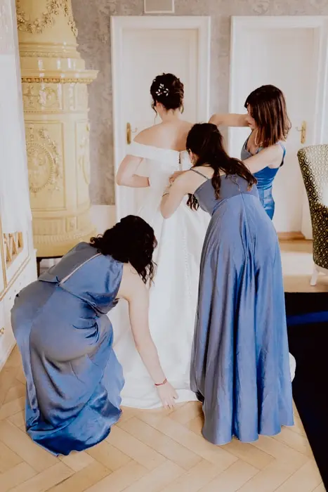 Hochzeitsfotograf Bayern Brautvorbereitung mit Helferinnen in eleganten blauen Kleidern Dokumentarische Editorial Hochzeitsfotografie