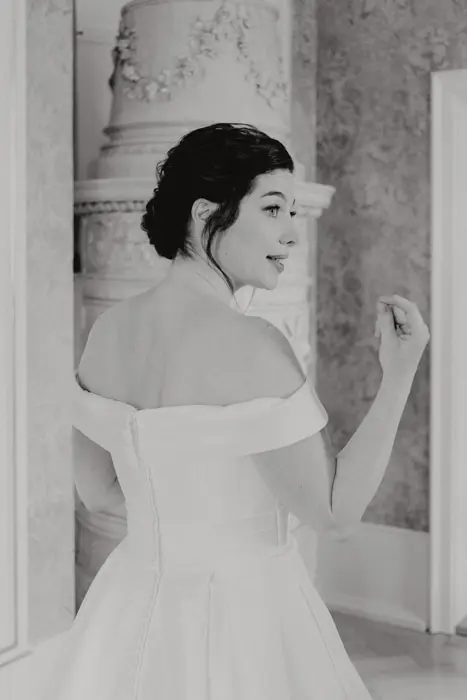 Hochzeitsfotograf Bayern Braut in eleganten, schulterfreien Kleid in klassischem, stilvollen Raum Dokumentarische Editorial Hochzeitsfotografie