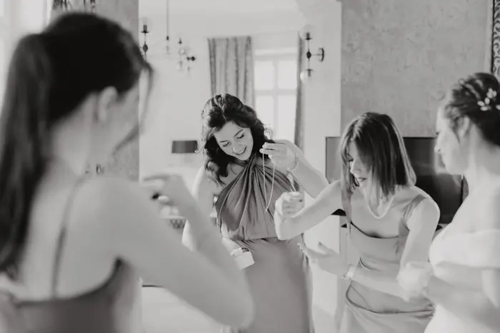 Hochzeitsfotograf Bayern Vier Frauen lachen zusammen in einem eleganten Zimmer Dokumentarische Editorial Hochzeitsfotografie