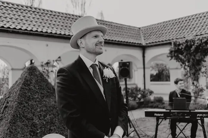 Hochzeitsfotograf Bayern Eleganter Bräutigam im Zylinder bei einer Hochzeitszeremonie Dokumentarische Editorial Hochzeitsfotografie