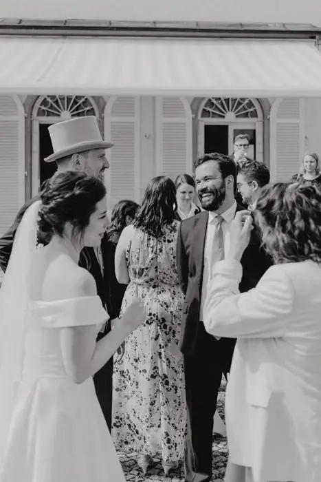 Hochzeitsfotograf Bayern Hochzeitsgesellschaft mit Braut und Bräutigam vor herrschaftlichem Gebäude Dokumentarische Editorial Hochzeitsfotografie