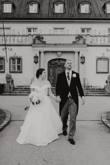 Hochzeitsfotograf Bayern Hochzeitspaar vor historischer Villa in Schwarz-Weiß Dokumentarische Editorial Hochzeitsfotografie