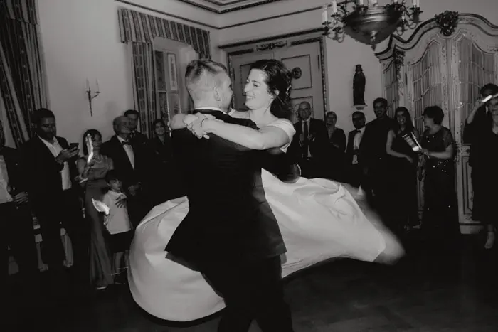 Hochzeitsfotograf Bayern Brautpaar beim Tanz in einem eleganten Ballsaal umgeben von Gästen Dokumentarische Editorial Hochzeitsfotografie