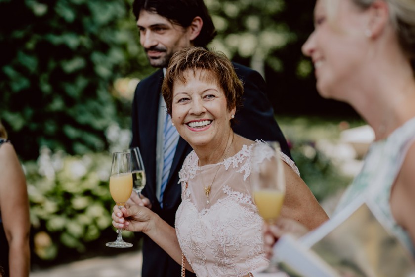 Brautmutter lacht mit Gästen auf der Hochzeitsfeier im Fischer in Inning am Ammersee