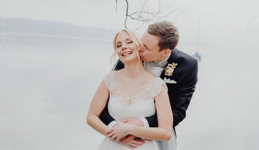 Bräutigam gibt der Braut einen Kuss beim Fotoshooting