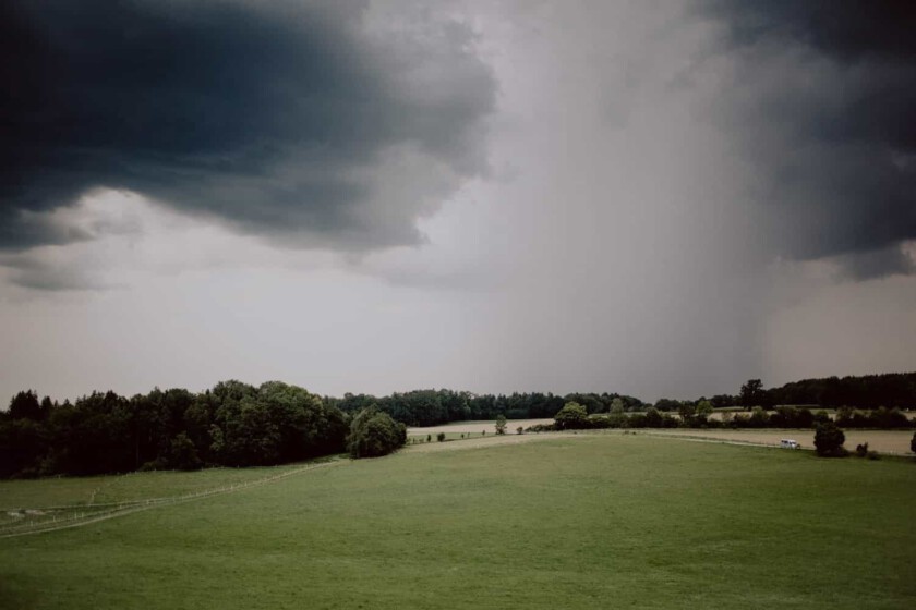 Landschaftsaufnahme Nähe Gut Georgenberg südlich von München. Man sieht ein starkes Gewitter und dunkle Wolken in der Ferne