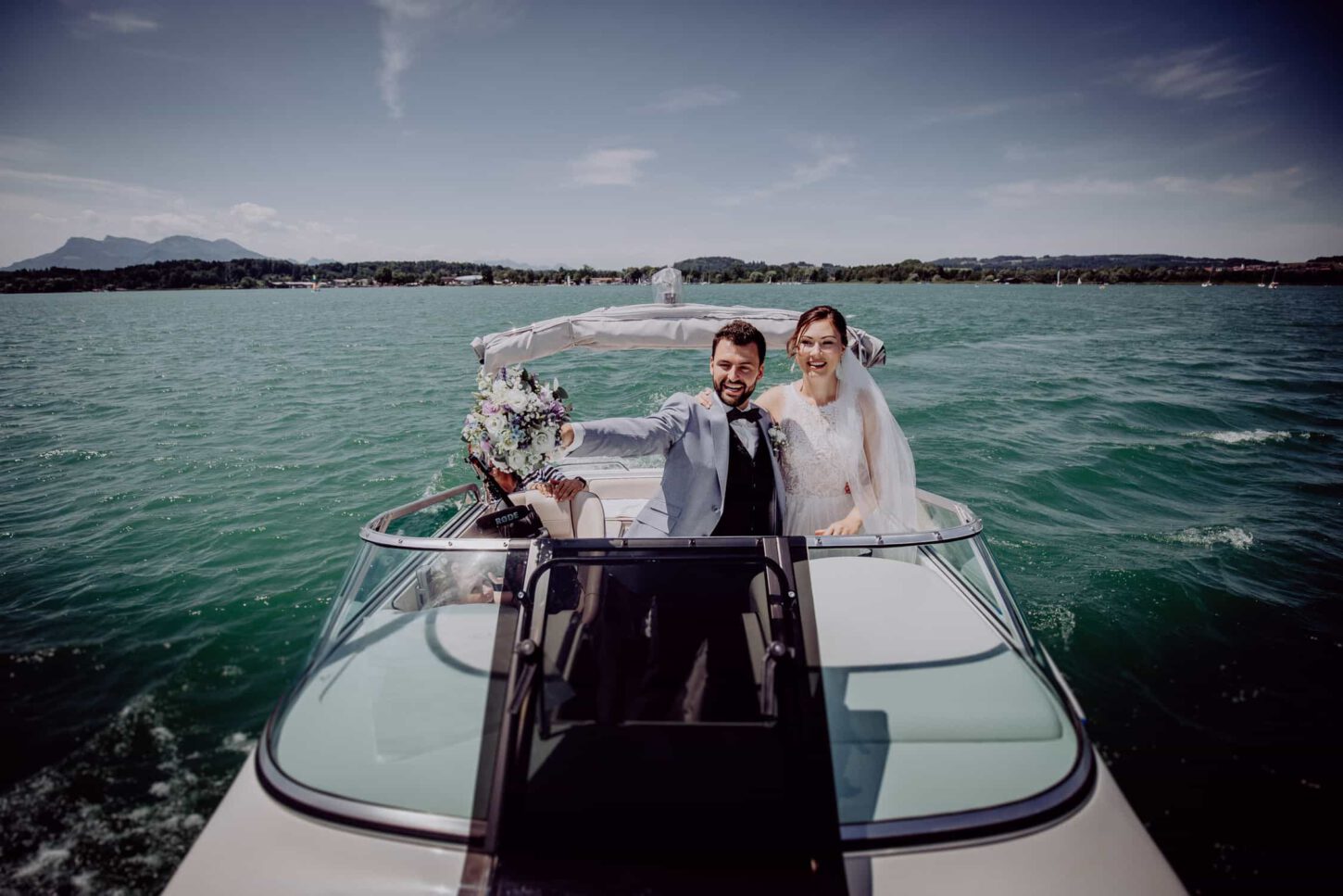 Brautpaar auf einem Boot auf dem Chiemsee. Aufgenommen während der Hochzeit im Gut Aiterbach