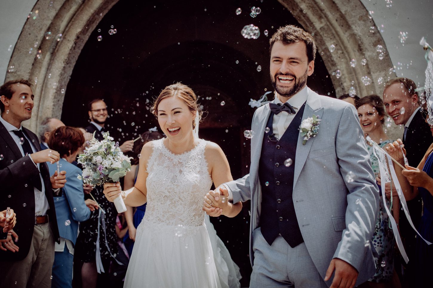Auszug des Brautpaares aus der Kirche mit Seifenblasen, fotografiert von Chris Hartlmaier Fotodesign
