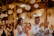 Braut und Bräutigam sitzen bei ihrer Hochzeitsfeier auf Stühlen und lachen in der Mühle in Holzham