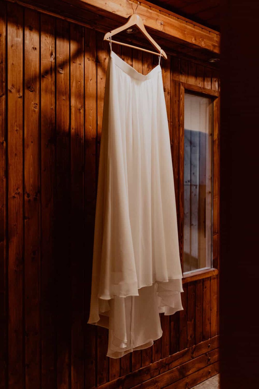 Das Brautkleid hängt an einem Bügel beim Getting Ready