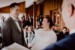 Brautpaar lacht stark bei der Trauung im Almbad Huberspitz. Im Hintergrund lachen Hochzeitsgäste.