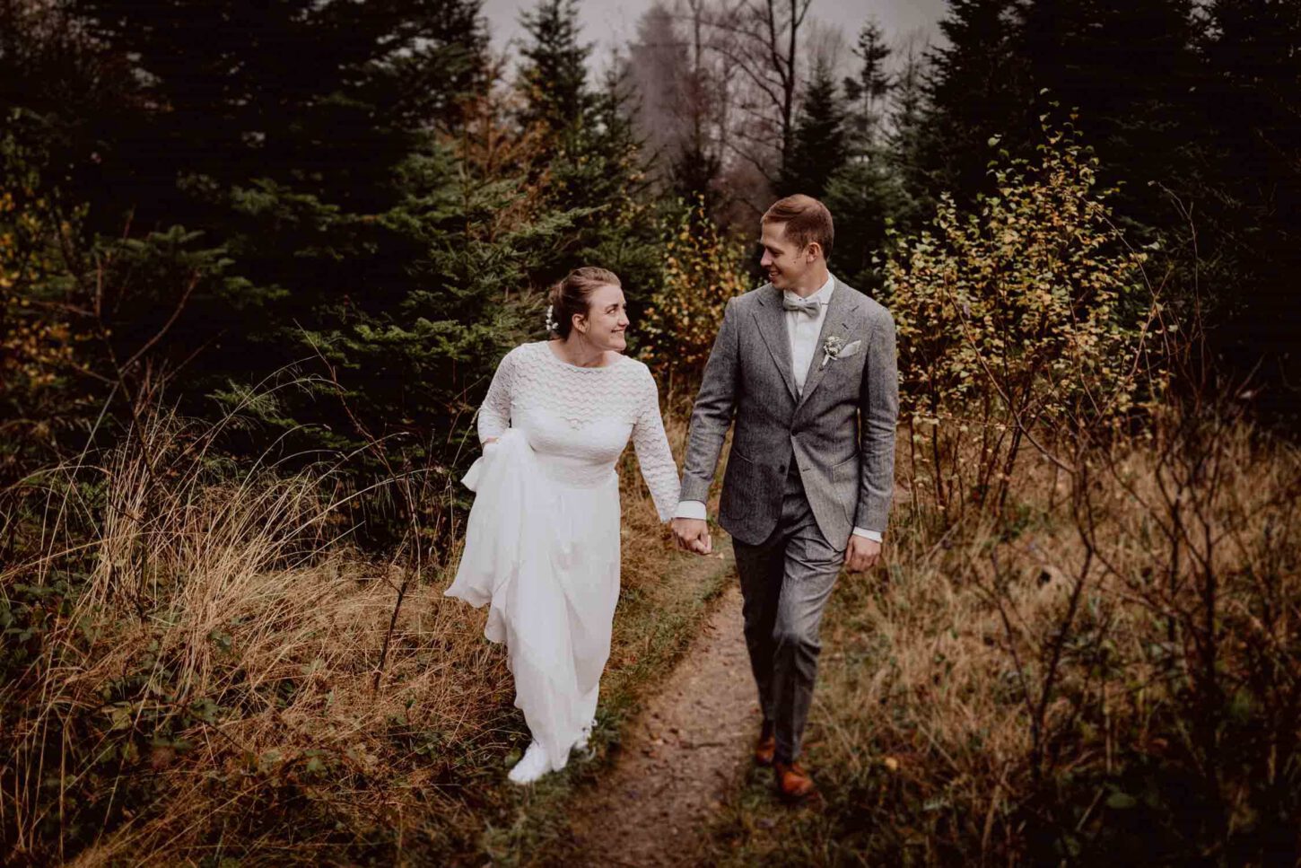 Brautpaar läuft in alpiner Umgebung beim Brautpaarshooting und lacht zusammen