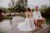 Braut und Bräutigam sitzen bei der freien Trauung auf Stohballen und lachen
