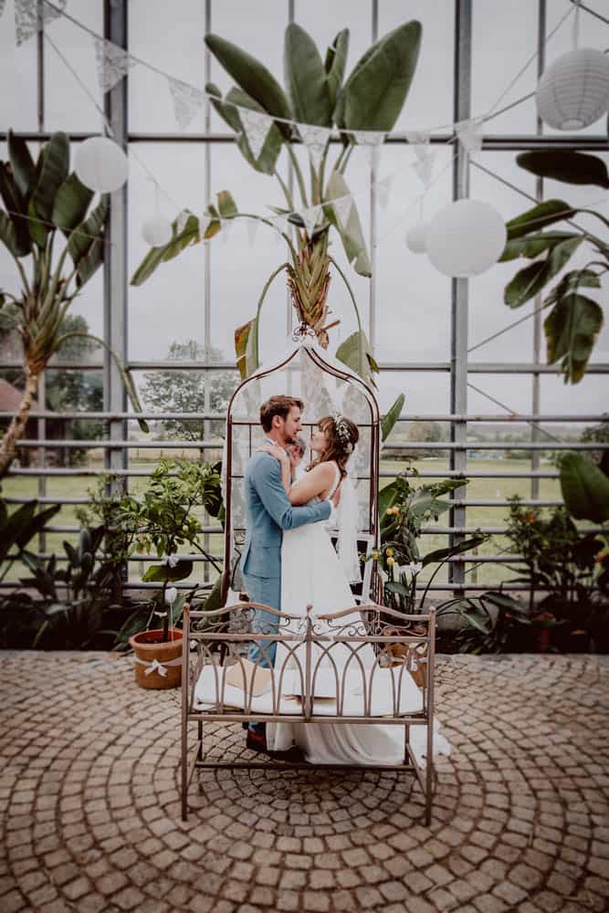 Brautpaar steht während ihrer Hochzeit im Fünfseenland im Flora Dome Entraching und umarmt sich.