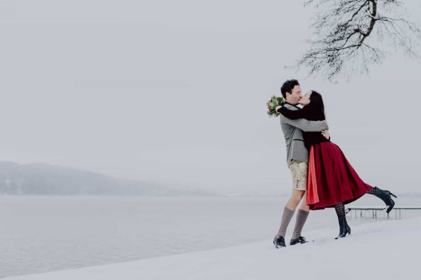 Paar gibt sich einen Kuss beim Paarshooting in winterlicher Landschaft