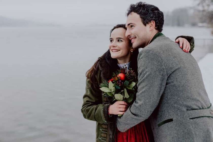 Paar umarmt sich beim Paarshooting. Im Hintergrund sieht man einen See