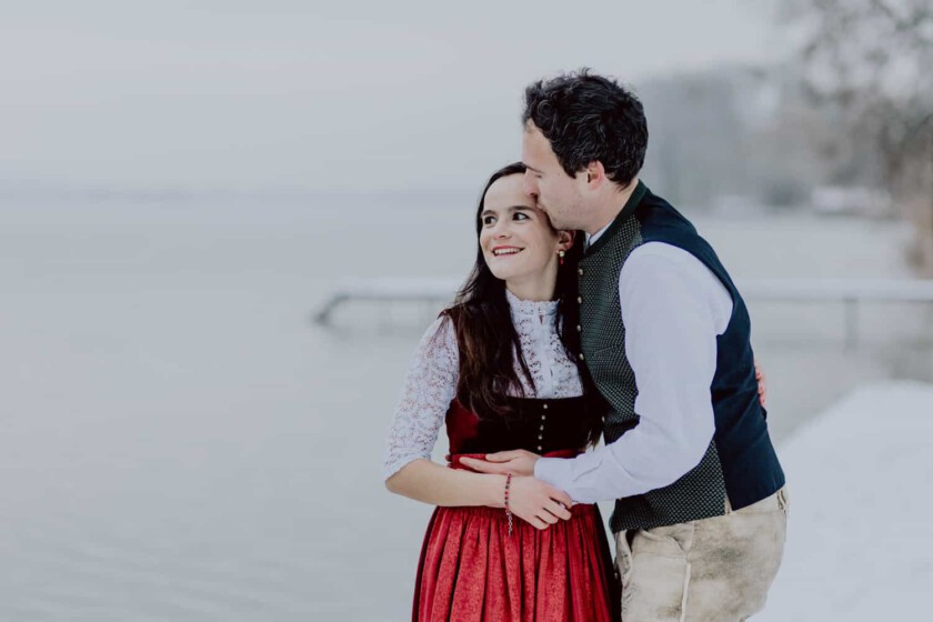 Pärchen umarmt sich beim Paarshooting in verschneiter Landschaft