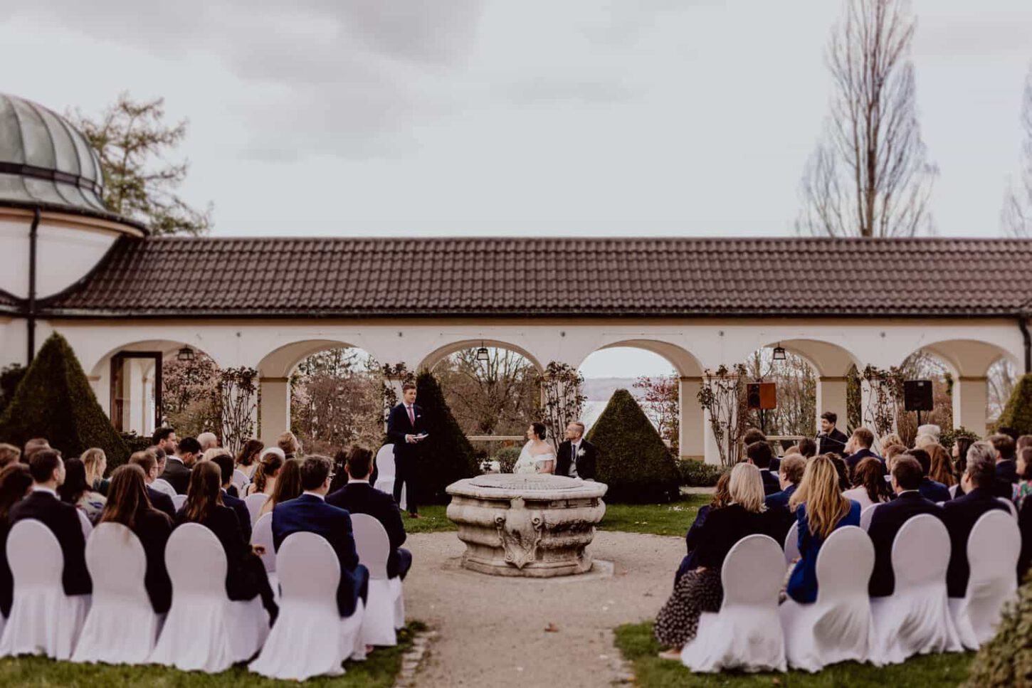 Trauredner mit Brautpaar und Hochzeitsgästen während Zeremonie im Schloss Höhenried