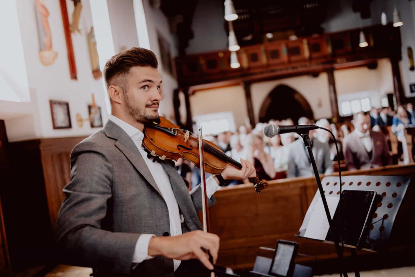 Hochzeitsmusiker spielt Geige in einer Kirche. Hochzeitstipp vom Fotograf Chris Hartlmaier