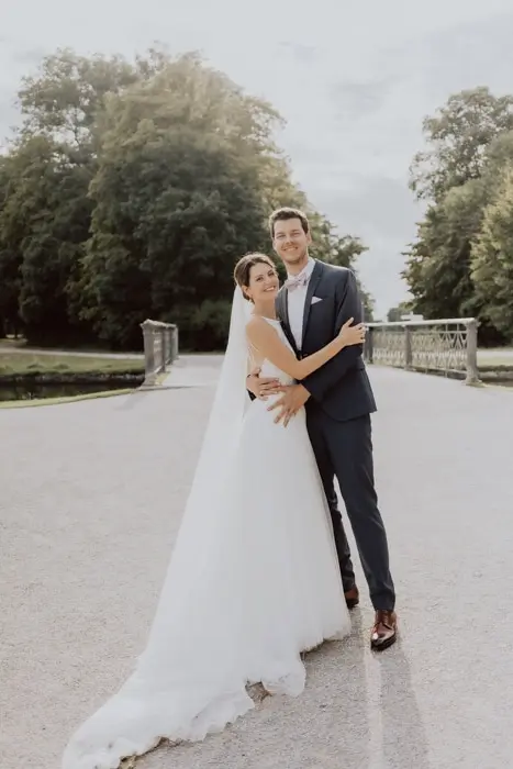 Hochzeitsfotograf Bayern Brautpaar umarmt sich auf einer Brücke im Park Dokumentarische Editorial Hochzeitsfotografie