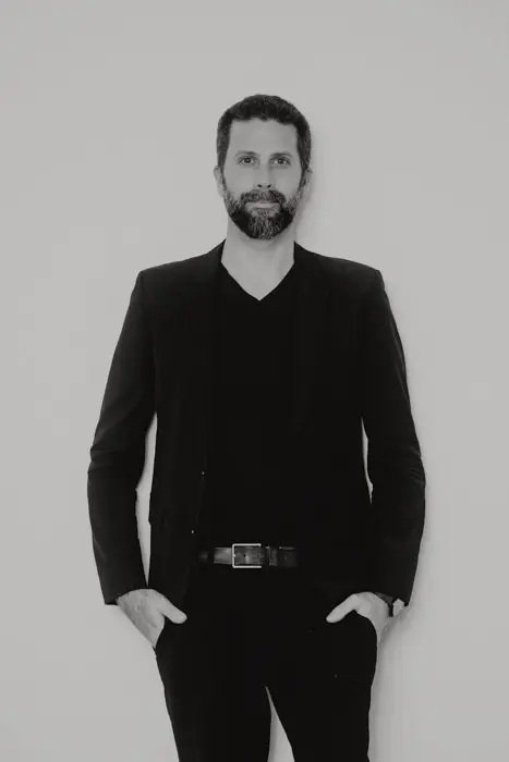 Hochzeitsfotograf Bayern Schwarz-weiß Porträt eines bärtigen Mannes in Anzug und T-Shirt Dokumentarische Editorial Hochzeitsfotografie