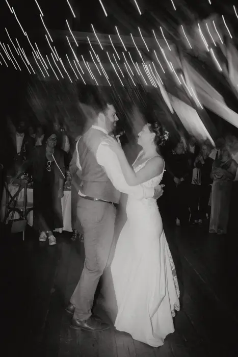 Hochzeitsfotograf Bayern Brautpaar tanzt unter Lichterketten in einem festlichen Saal Dokumentarische Editorial Hochzeitsfotografie